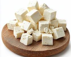 Fresh organic cow milk paneer cubes on a wooden board at SAAM farm Islamabad